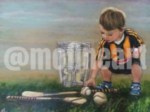 Boy Kilkenny GAA with the Liam McCarthy Cup and a hurl and slitter