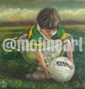 Little boy Kerry Jersey in the Sam Maguire holding a football