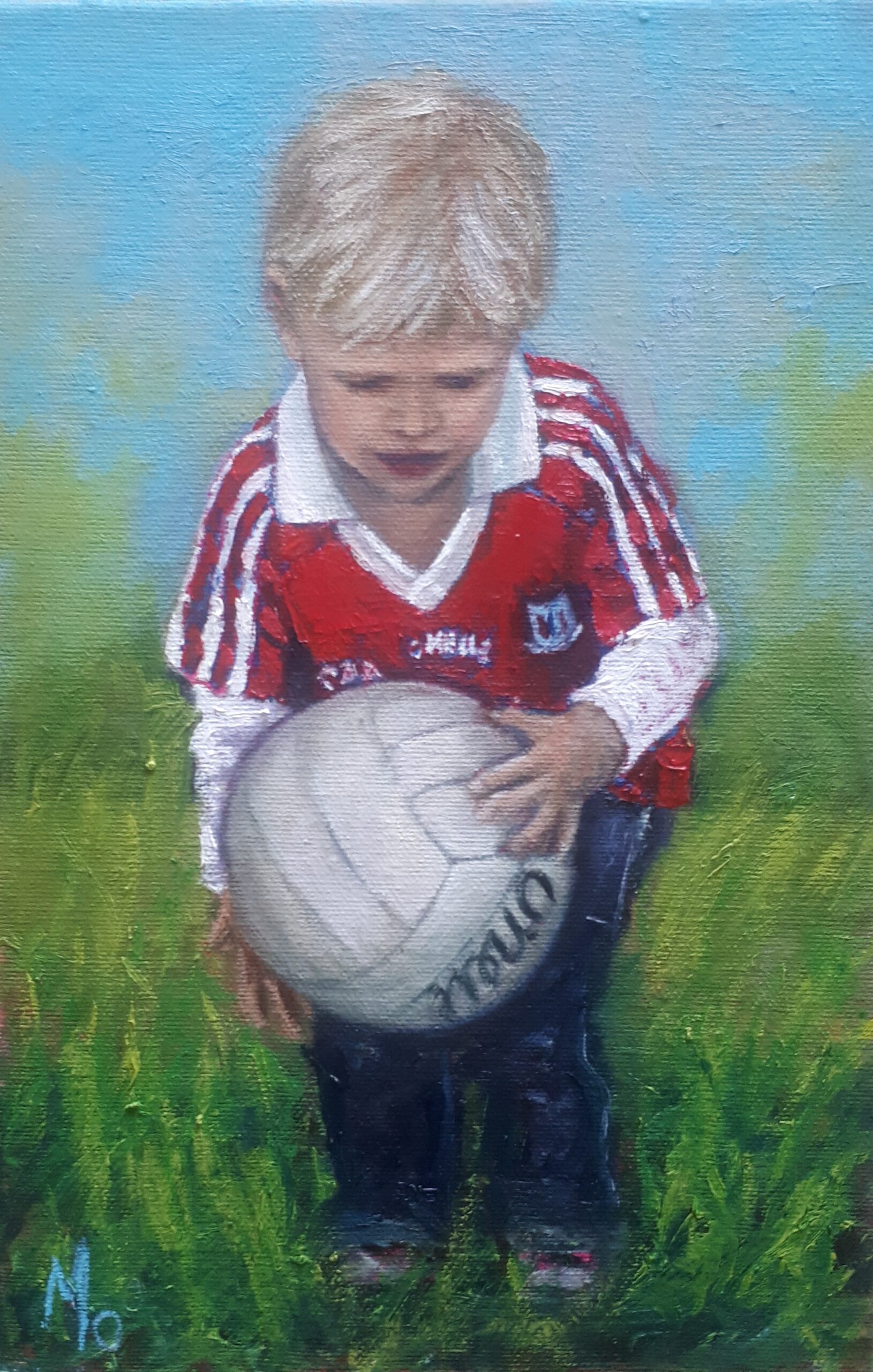 young boy with red jersey with football