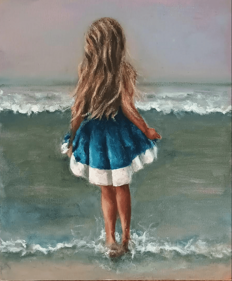 Little Girl in a blue dress at the edge of the Atlantic Sea